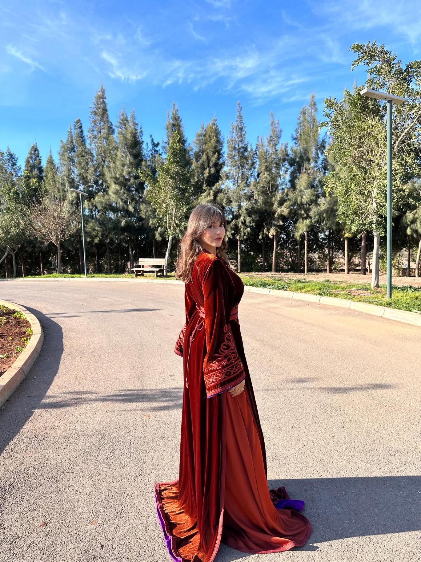 Caftan en velours rouille avec traîne, porté en extérieur