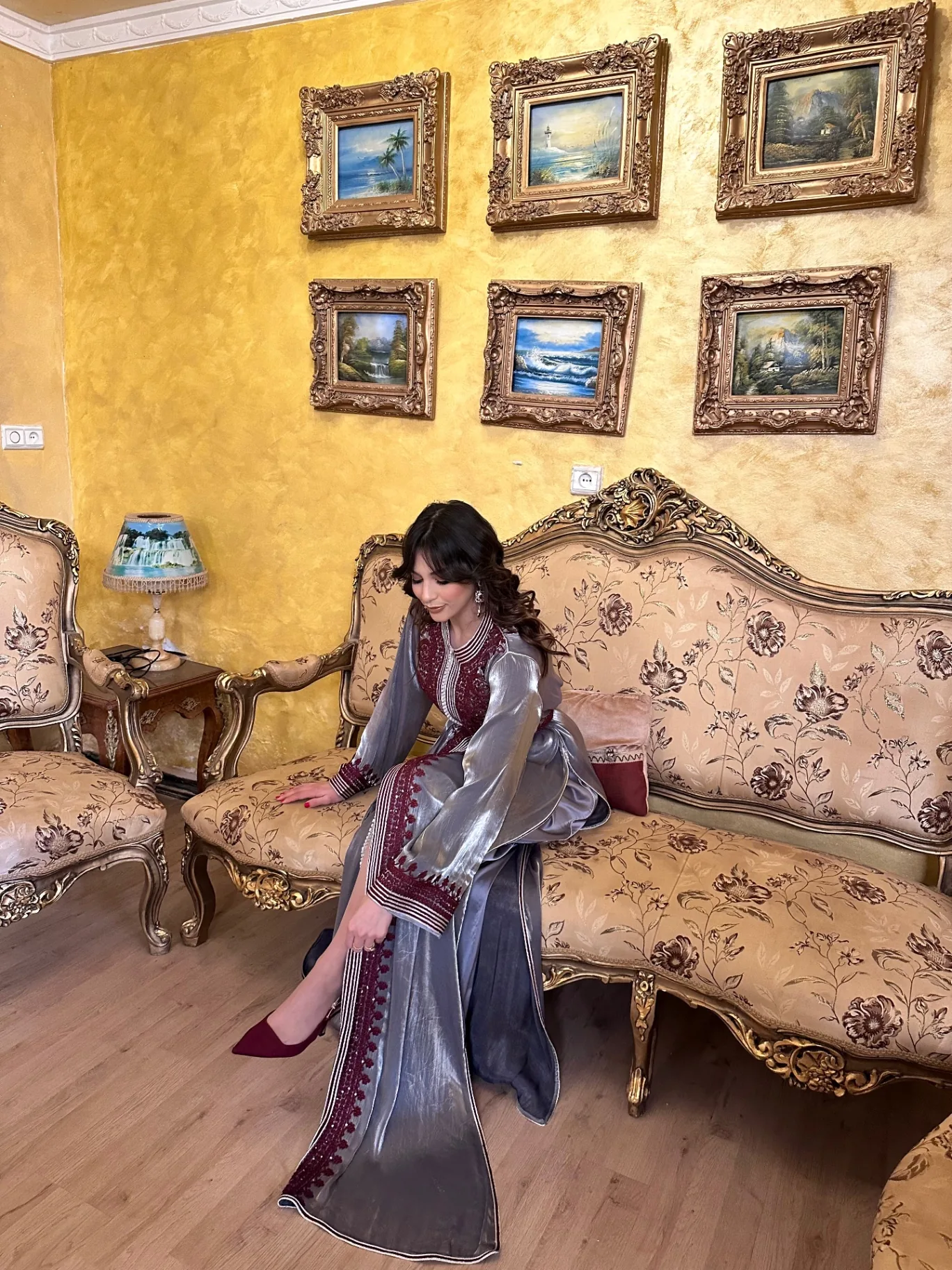 Caftan argenté brodé bordeaux, drapé sur un salon marocain doré